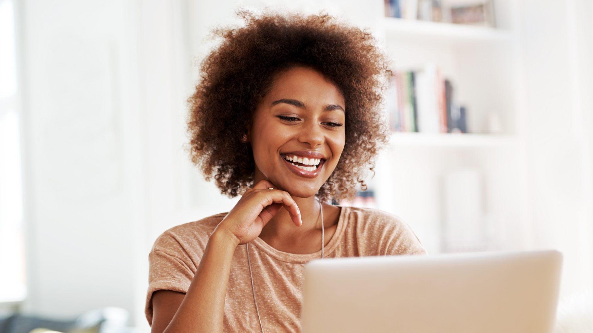 Smiling woman on a laptop video call at home — online therapy in Colorado
