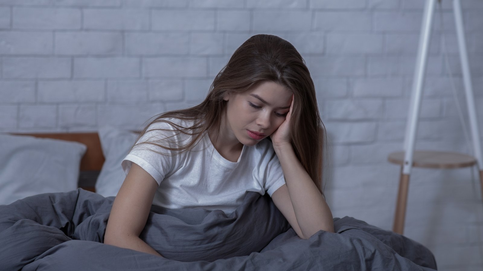 Woman resting in bed — postpartum perinatal therapy Denver Colorado